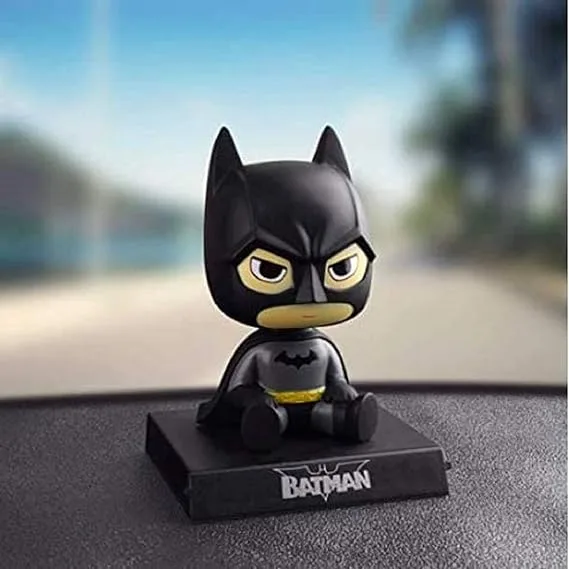 Batman action figure sitting on car dashboard